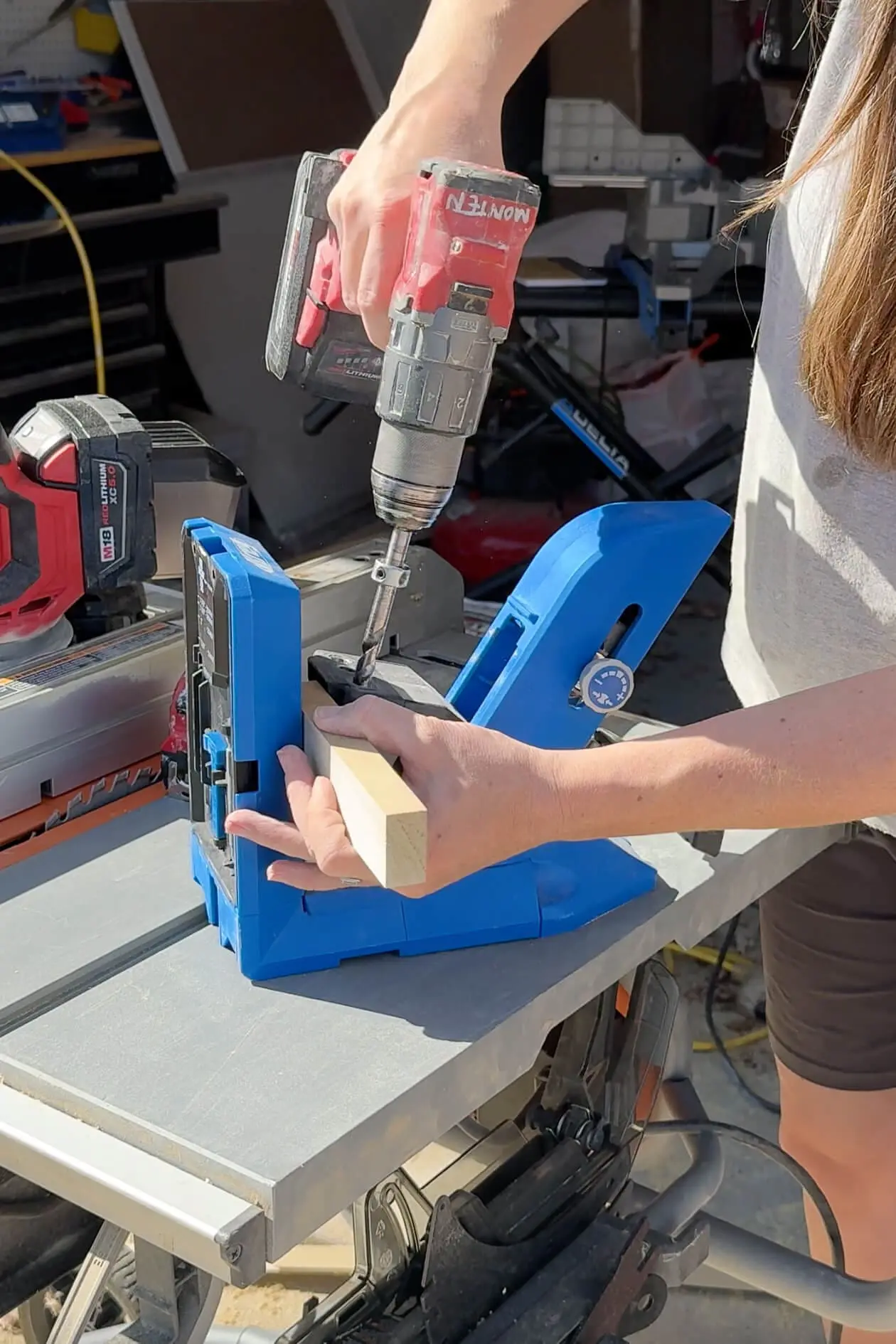 Drilling pocket holes into a support piece using a Kreg jig and cordless drill for a built-in bookcase.